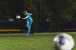 © PoppyPix - young girl kicking a ball at the late evening practice in a stadium, full shot, active teenage life. High quality photo