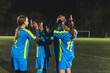 © PoppyPix - group of happy teenage football girls clapping each other while practicing football at night. High quality photo