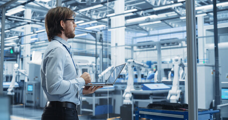 Poster - Factory Manager Working on Laptop at a Futuristic Industrial Manufacture with Autonomous Support Robots. Specialist Monitoring Technical Data on a Computer, Analyzing Reports and Planning Updates