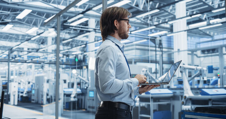 Aufkleber - Experienced Male Engineer Standing in Office, Using Laptop Computer and Overlooking Production at a Modern Automated Electronics Assembly Line with AI Support. Factory Executive at Work