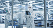 © Gorodenkoff - Portrait of a Female Worker Wearing Full-Body Protective Coveralls, Mask and Goggles at a Biotechnology Manufacturing Plant. Young Specialist Using a Tablet Computer, Overlooking Nanotech Production