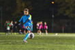 © PoppyPix - teenage girl soccer player practicing with football ball, Young sportive girl training in blue uniform. High quality photo