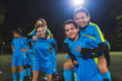 © PoppyPix - teenage girls football team having fun during a break at the late evening practice, blue uniforms, team sport and girls concept. High quality photo