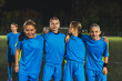 © PoppyPix - teenage girl football players huddling together, medium shot, evening practice, outdoors. High quality photo