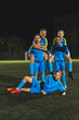 © PoppyPix - vertical shot of several young football player girls in blue uniforms posing for the camera, teamwork concept. High quality photo