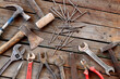 © Mariia - Old hand tool on a wooden surface. Adjustable wrench, spanner, axe, hammers, nails and pliers. Tools for repair and construction, top view. Construction background. Composition from an old rusty tool