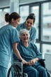 © IQRAMULSHANTO - A nurse and doctor stand next to an elderly woman in wheel chair in the hospital.