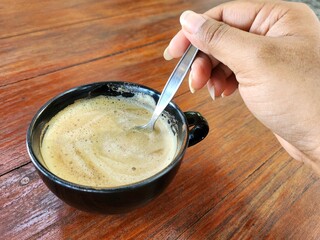 Selfie of latte coffee with milk on hand