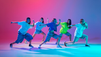 Wall Mural - Five kids strike dynamic hip hop poses with intense focus and style against gradient pink purple background in neon light. Concept of modern dance styles, youth culture, active lifestyle