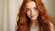 © ALA - Portrait of a smiling cheerful teenage girl with long red hair and perfect skin, creamy beige background, banner.