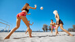 © master1305 - Young people, men and women, friends in beach wear fully engaged in a beach volleyball game, playing under clear blue sky. Concept of sport, summer activity, leisure games, friendship