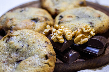 Close up of freshly baked cookies, chocolate and nuts in blurred background