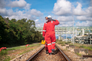 Wall Mural - Surveyor engineers team wearing safety uniform and blueprint checking inspection by theodolite telescope to measurement level position railway construction site is industry transportation concept.