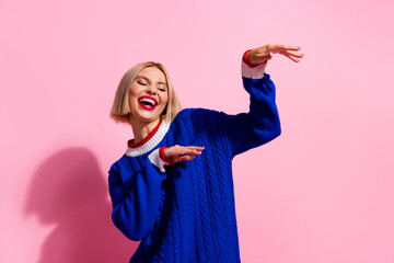 Wall Mural - Photo portrait young girl wearing blue knitted sweater boogie woogie weekend of clubber raised hands up isolated on pink color background