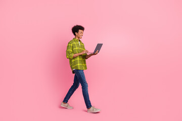 Poster - Full length portrait of nice young man walk use laptop wear shirt isolated on pink color background