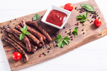 Grilled sausages with tomatoes , pepper and rosemary`. BBQ food background