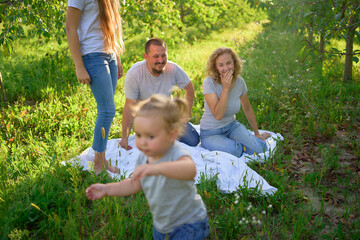 Wall Mural - toddler screams and cries in front of family on picnic in garden