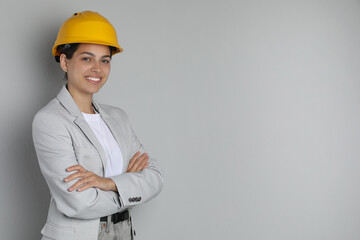 Wall Mural - Engineer in hard hat on grey background, space for text