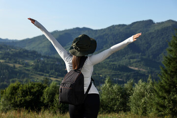 Canvas Print - Woman with backpack in beautiful mountains, back view