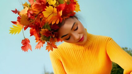 Poster - Fall Smiling Woman Wearing a Headpiece of Autumn Flowers and Leaves in a Yellow Sweater with Eyes Closed against a Soft Blue Background