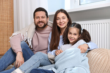 Wall Mural - Happy family near heating radiator at home