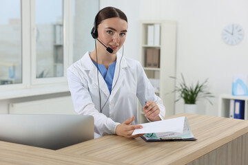 Sticker - Professional receptionist working at wooden desk in hospital