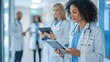 © yailek - Healthcare professionals collaborating in a modern hospital setting, utilizing digital devices for patient care and information.