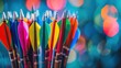 © buraratn - A set of colorful arrows arranged neatly in a quiver, with a blurred archery range in the background