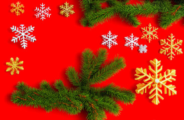 red Christmas background with snowflakes and fir branches with an empty text space in the center. a greeting card