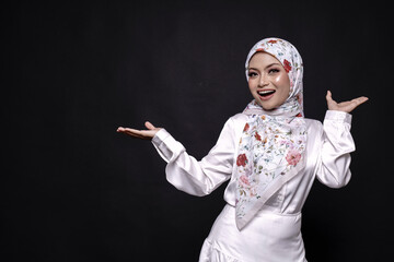 Asian hijab girl in white dress and hijab, give a  happy hand gesture isolated over black  background in studio. People emotions lifestyle concept.