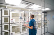 © OscarStock - A veterinarian in blue scrubs observes the recovery process of animals in a high-tech veterinary facility. The room is equipped with advanced medical technology.