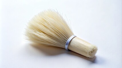 A delicate, snowy-white paintbrush with soft, fluffy bristles sits upright on a clean, white background, awaiting its next creative stroke.