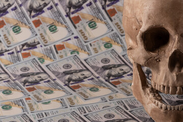 Human skull against the background of 100 US dollar bills