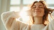 © Dulemegapixel - A woman with beautiful features enjoys the warm sunlight, eyes closed and smiling, wearing a cozy sweater, capturing a serene and blissful indoor moment.