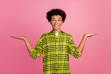 Poster - Portrait of nice young man hold empty space scales wear shirt isolated on pink color background