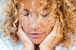 © simona - Introspection and meditation concept lifestyle with one woman alone close up portrait touching softly her face with both hands having care. Thoughts and difficulty concept life moments. Female people
