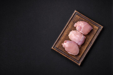 Fresh chicken fillet on a dark concrete table with spices and herbs