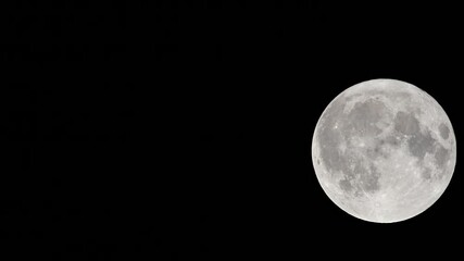 full moon against a black night sky. close-up of the full moon illuminated against a pitch-black nig