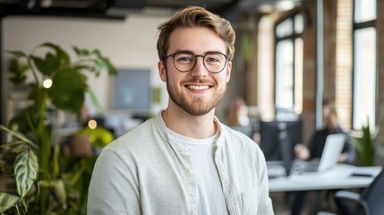 Portrait of a smiling young caucasian man working in a startup company office