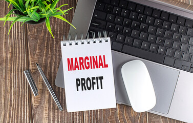 Poster - MARGINAL PROFIT text on a notebook with laptop, mouse and pen .