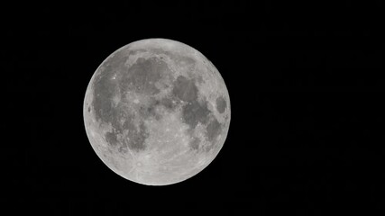 full moon against a black night sky. close-up of the full moon illuminated against a pitch-black nig