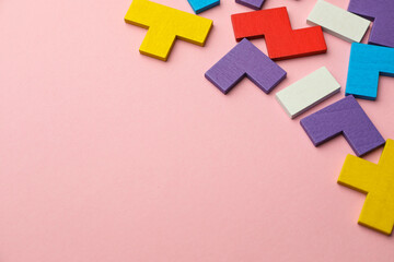 Wall Mural - Colorful wooden puzzle pieces on pink background. Space for text