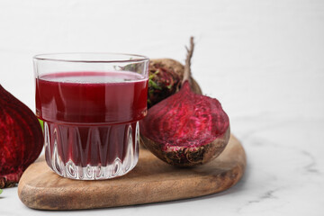 Wall Mural - Fresh beet juice in glass and ripe vegetables on white marble table, closeup. Space for text