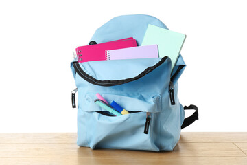 Sticker - Backpack with different school stationery on wooden table against white background