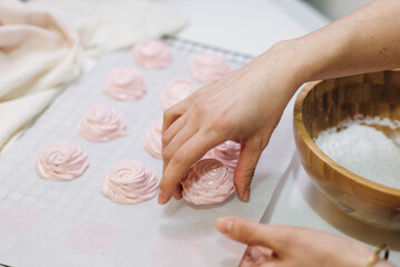 Homemade pink marshmallows on baking paper background on the kitchen