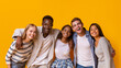 © Prostock-studio - Friendly group of multiethnic students embracing and smiling over yellow background
