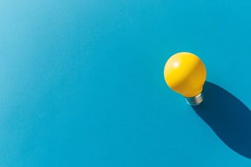 Poster - A single yellow light bulb is positioned flat against a bright blue backdrop, highlighting its design and color