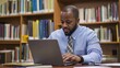 © PondLord - A focused education administrator reviewing student performance data on a laptop, surrounded by books and educational materials