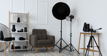 Wall Mural - Interior of light photo studio with armchair, shelf unit and different modern equipment