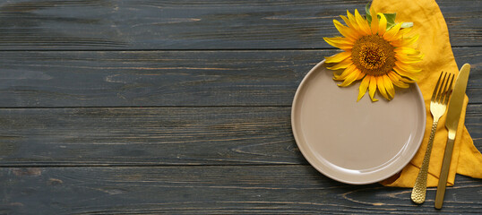 Wall Mural - Beautiful table setting with sunflower on black wooden background